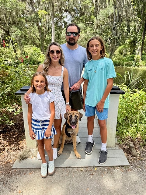 Family with dog in a park setting.